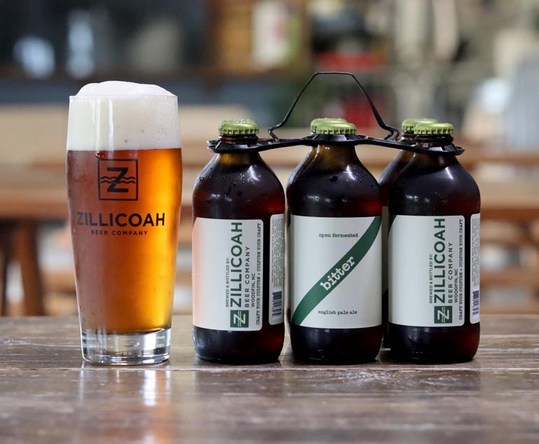 zillicoah brewing co bitter six pack of bottles next to a poured glass