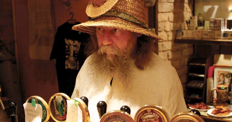 lithuanian bartender wearing amazing hat behind bar taps