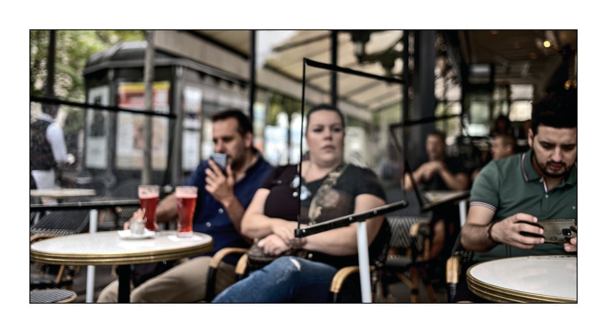 people drink beer outside divided by curtains due to COVID-19