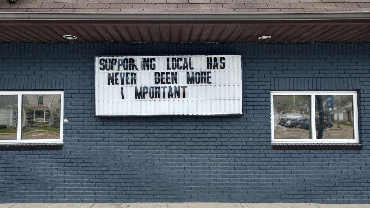 words of encouragement on street sign from local business during COVID-19