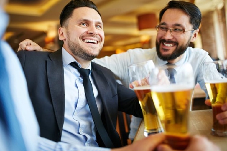 A group of men holding glasses of beer