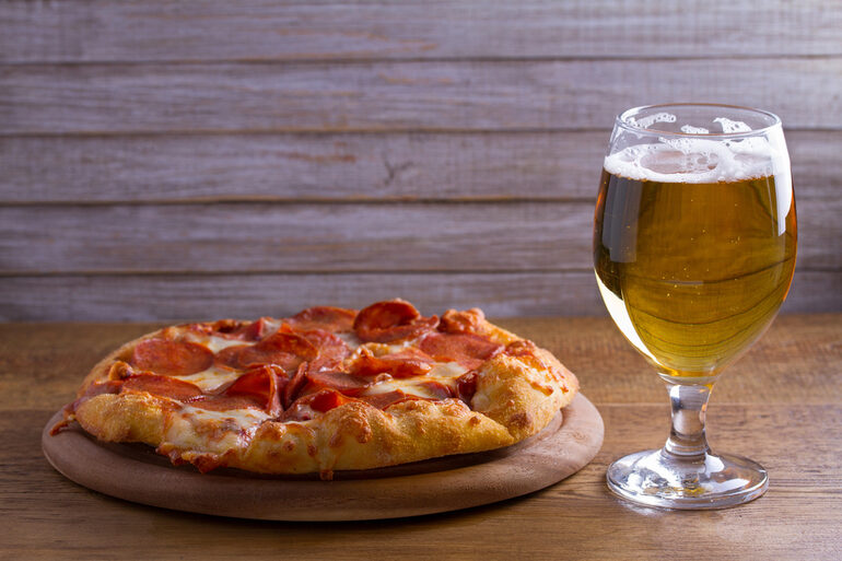 Pepperoni pizza and a glass of beer, showcasing the perfect pairing for an enhanced dining experience