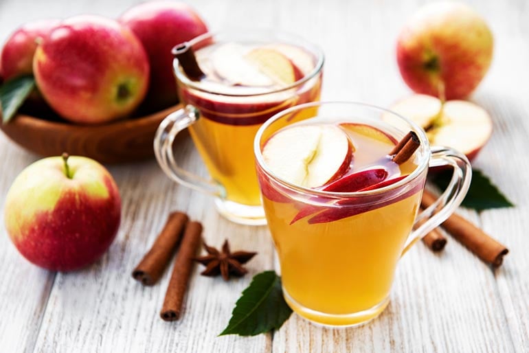 Spiced rum and apple cider punch with cinnamon sticks and apple slices.