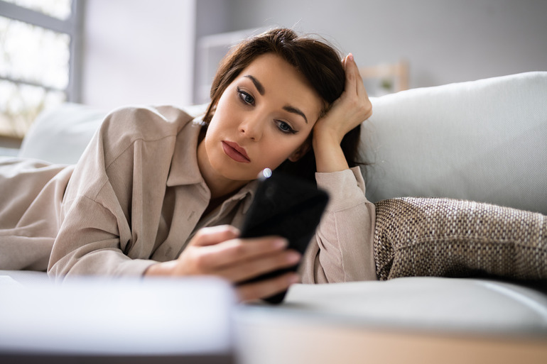 Woman using social media on phone with a bad mental condition