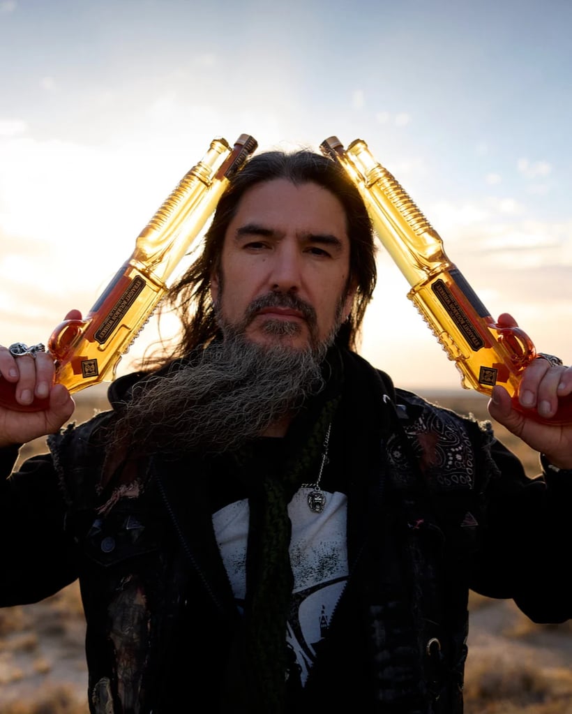 Robb Flynn of Machine Head with two bottles of the band's bourbon whiskey