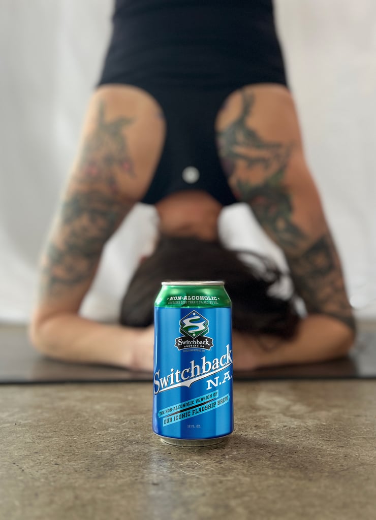 switchback na beer while woman does headstand for yoga