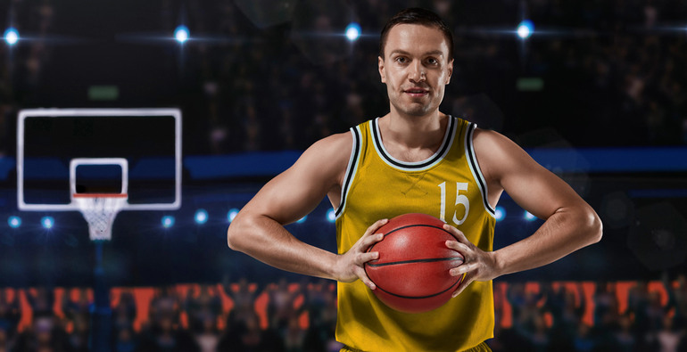 Basketball player in yellow uniform standing on basketball court