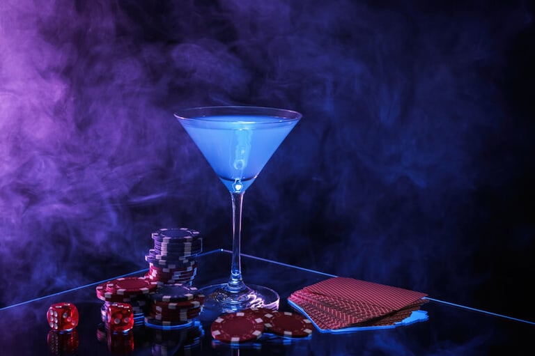 A glowing blue casino drink with poker chips and playing cards on a casino table