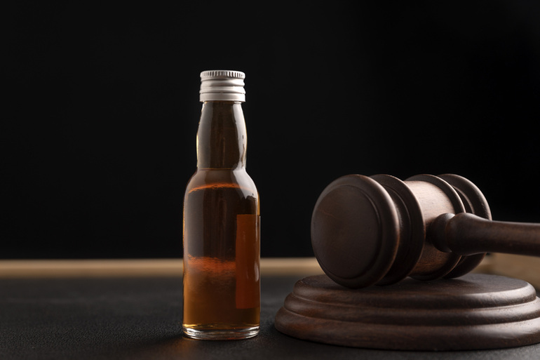 A bottle of beer beside a judge's gavel, symbolizing legal principles in emerging beer markets