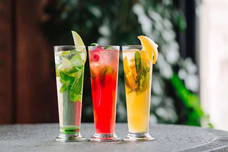 Cold non-alcoholic drinks with apples, oranges, and berries