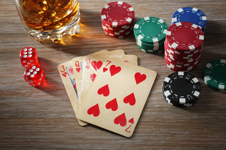 Playing cards, dice, and poker chips with the beer glass on the gambling table