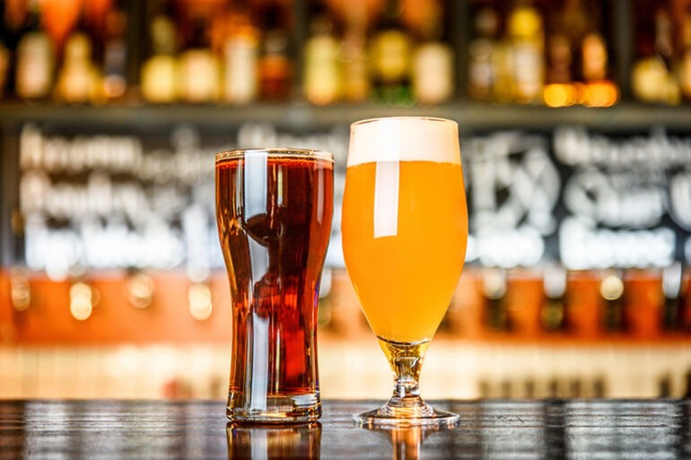 Glass of light and dark beer on a pub table, perfect for a weekend escape in New York