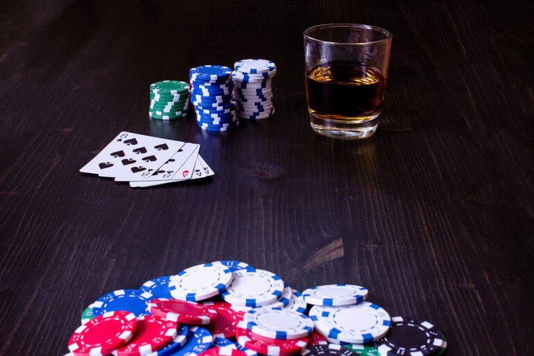 Beer glass with poker chips and playing cards on the table