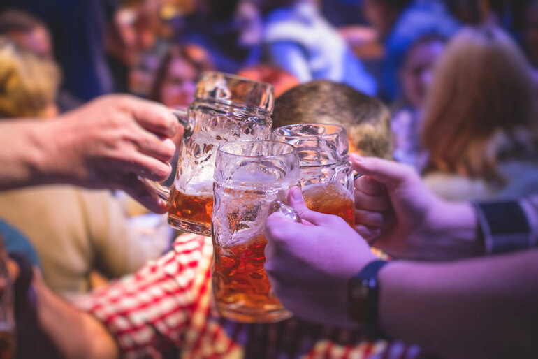 People toasting with beer mugs at a lively European summer beer festival