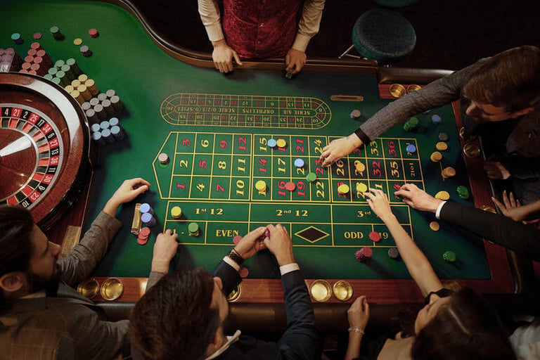 People playing roulette at a vibrant land-based casino table in South Africa