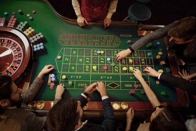 People playing roulette at a vibrant land-based casino table in South Africa