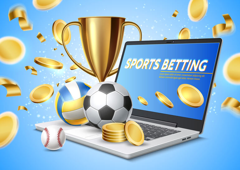 Baseball, football, basketball, and gold coins around a laptop displaying an online sports betting app