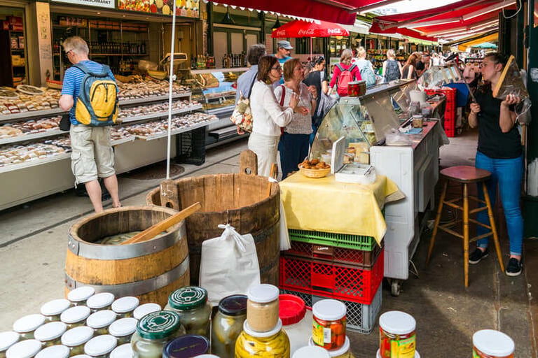 Busy French outdoor market with tourists shopping for local food, preserves, and regional products