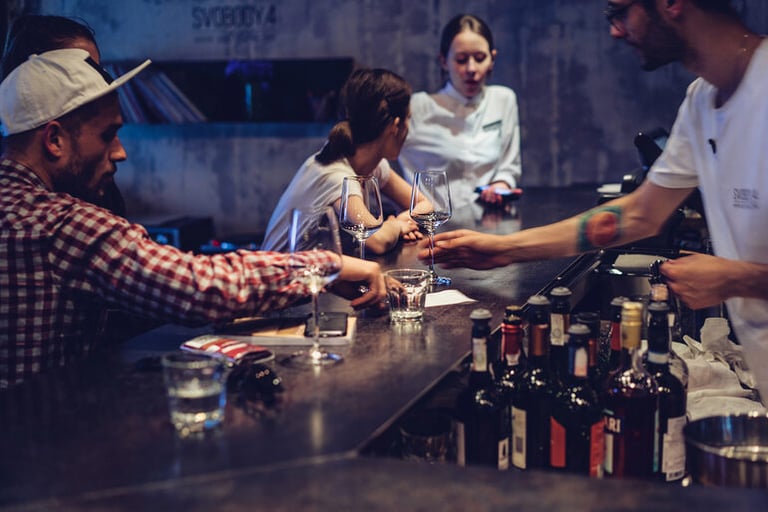 Bartender training in action at a modern bar with professionals practicing drink service and customer interaction