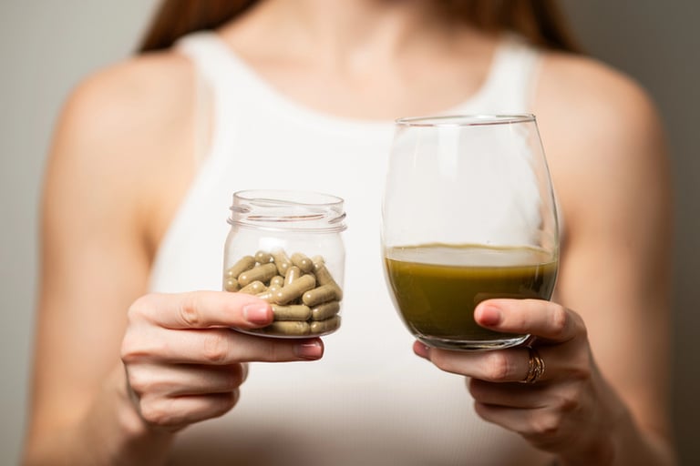 A girl holding a cup of Kratom Capsules and a glass of Kratom drink