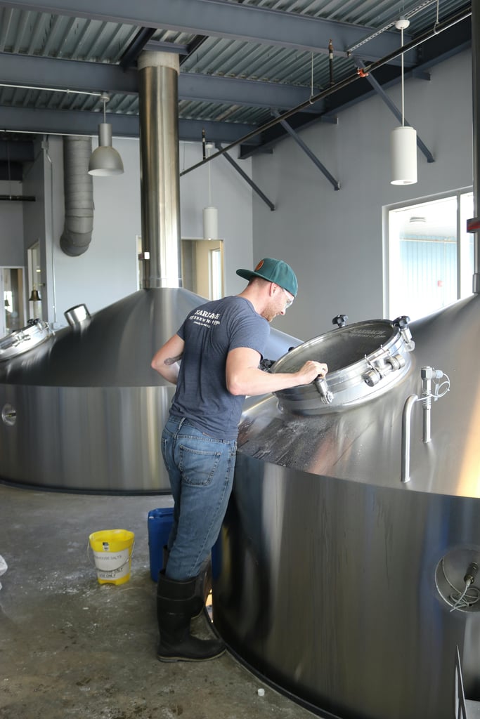 brewer checks out beer in a fermentation tank
