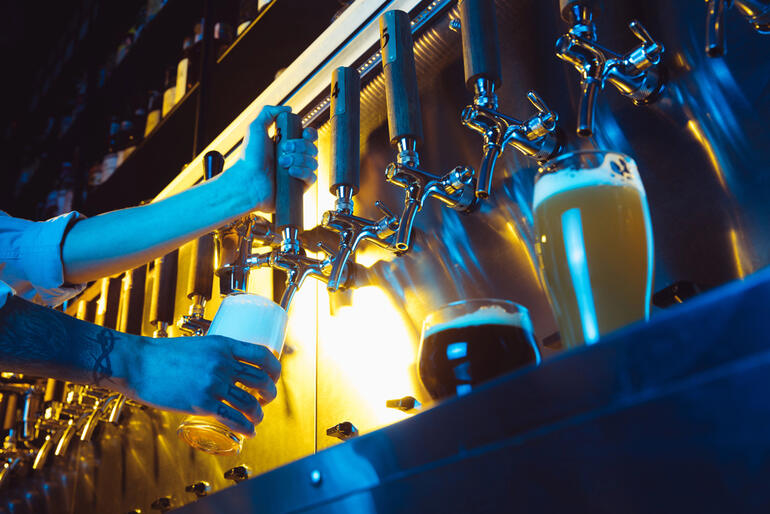 A beer lover is pouring craft beer from taps showcasing technology-driven brewery service efficiency