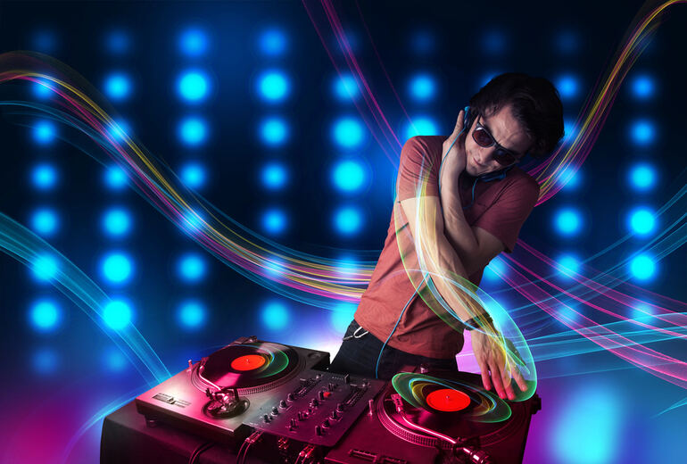 A DJ mixing music on turntables with colorful neon light trails