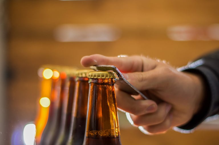 A native american opening a brown beer bottle with a bottle opener
