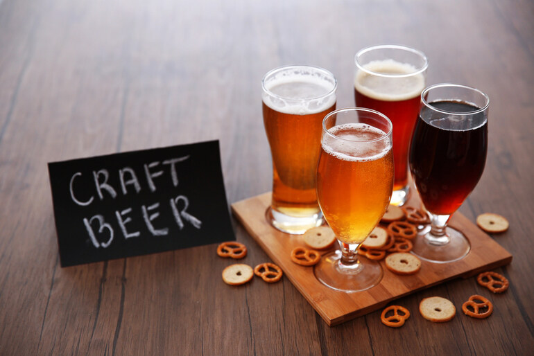 Glasses of craft beer with pretzels on a wooden table representing the rise of craft beer in Asia.