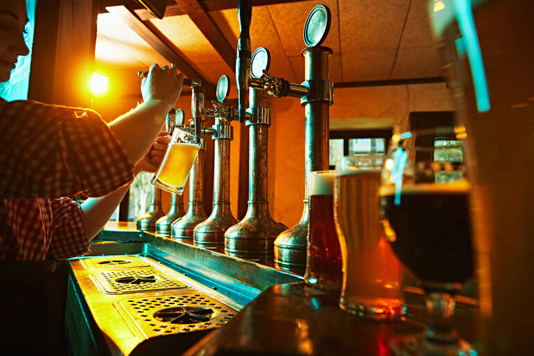 Bartender pouring a glass of craft beer in a brewery in Holland