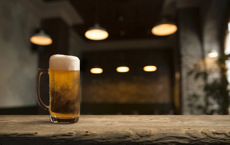 Cold glass of beer on rustic bar counter
