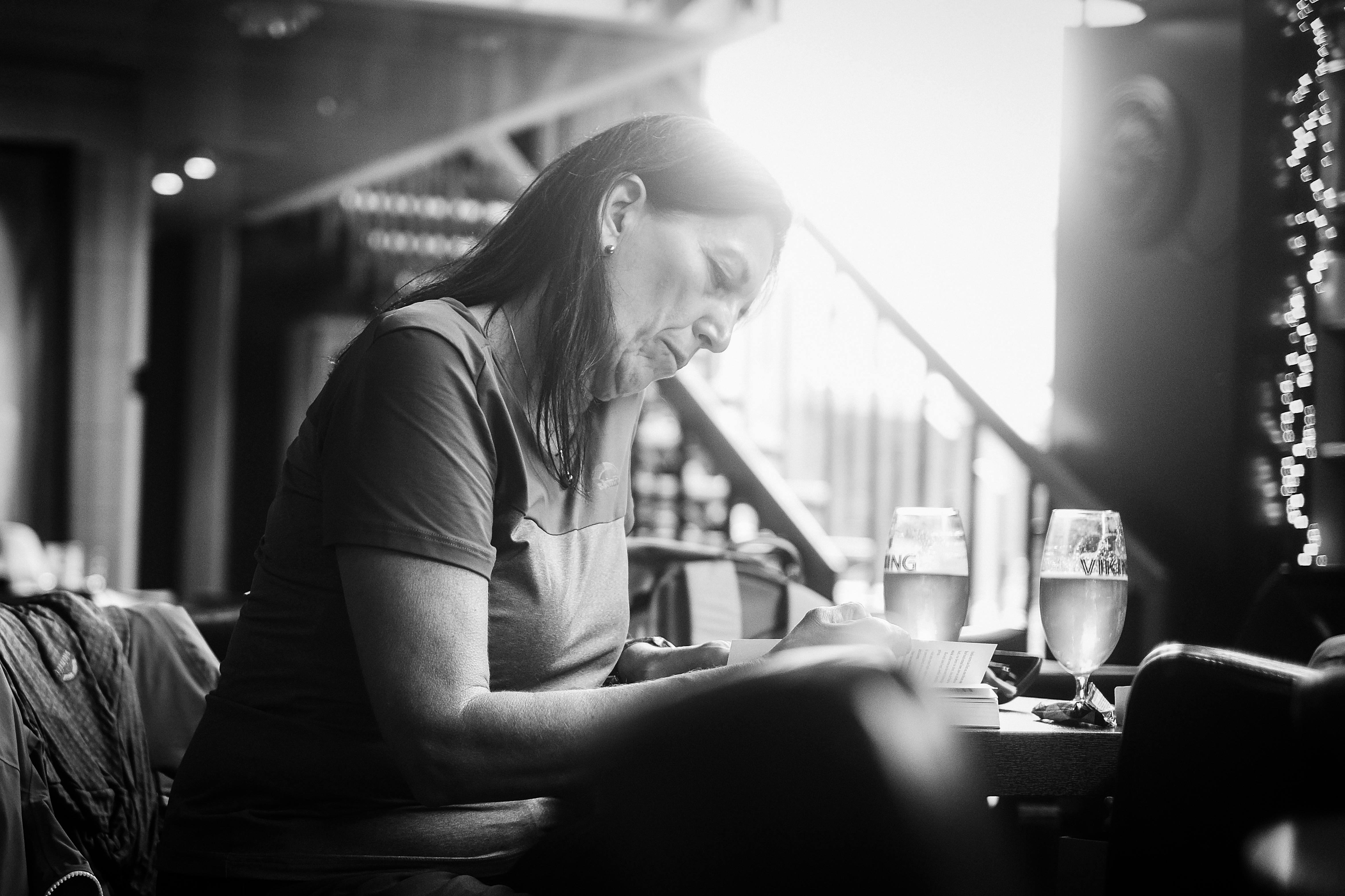 Women reading a book with a glass of beer