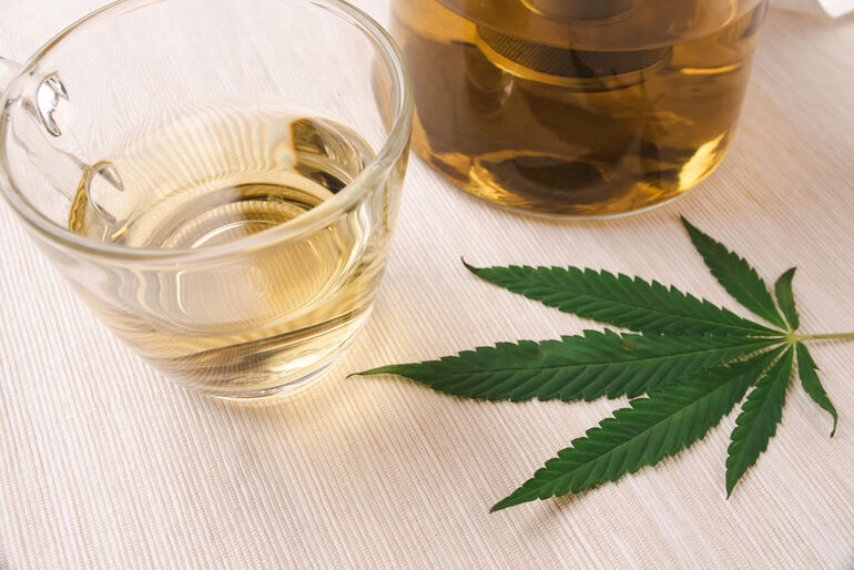 Cannabis leaf and alcohol illustrating the effects of simultaneous alcohol and cannabis use.