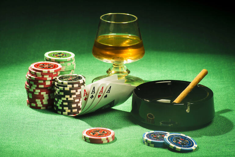 Casino chips, four aces, and a drink on a poker table illustrating the ease of joining Aussie pokies with PayID for players on the go.