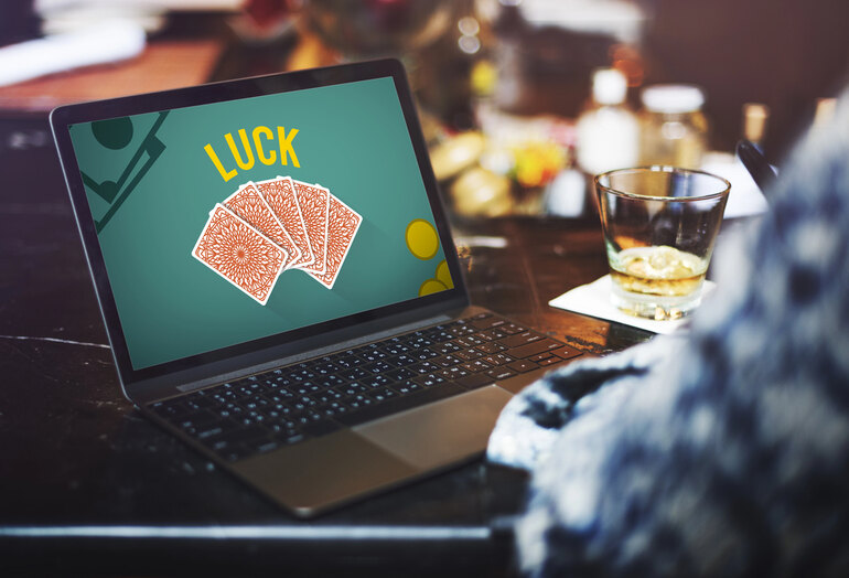 A man is playing online casino while drinking beer