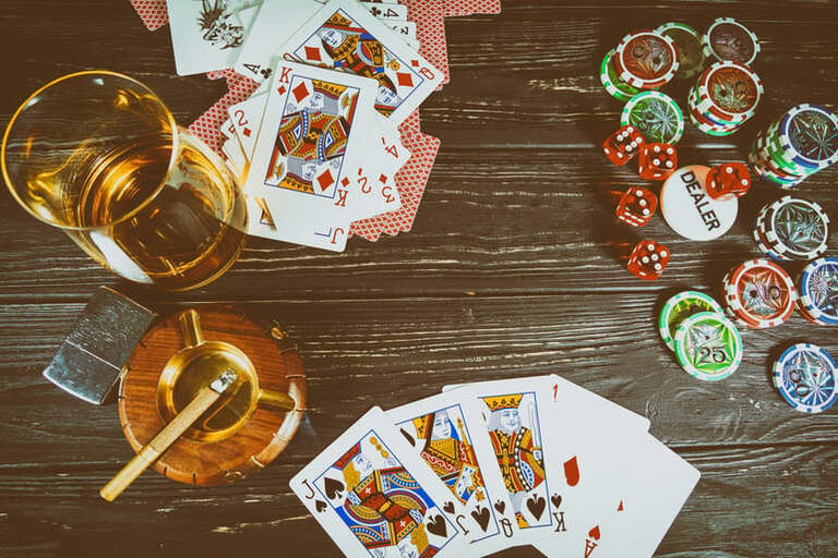Poker cards and gaming chips alongside a glass of craft beer, illustrating how gamification enhances table games and betting engagement for beer enthusiasts.
