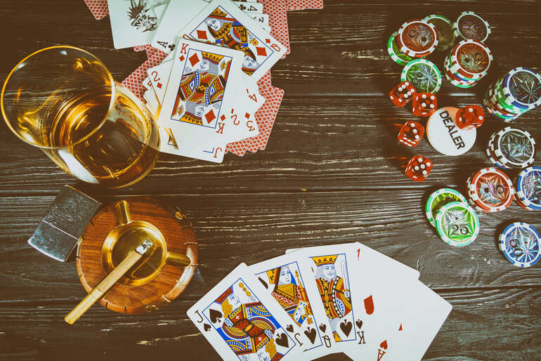 Poker cards and gaming chips alongside a glass of craft beer, illustrating how gamification enhances table games and betting engagement for beer enthusiasts.