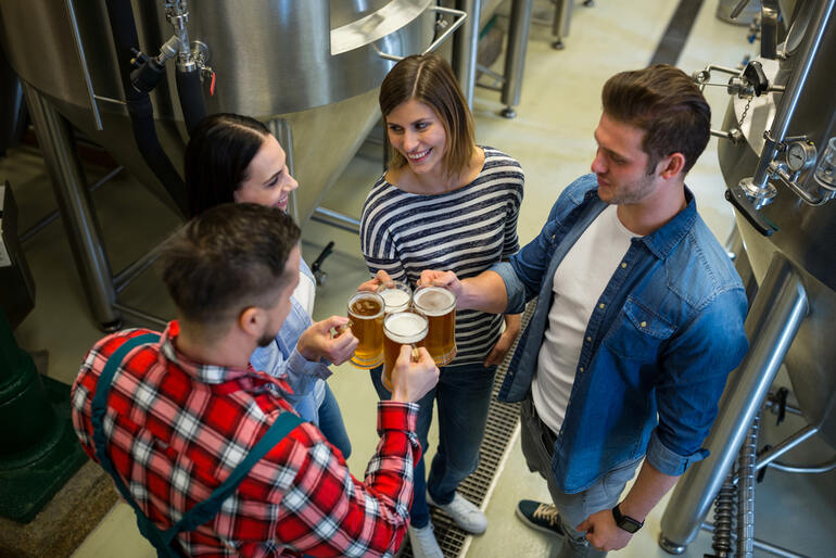 College students networking and tasting beer inside a brewery while learning about careers in the beverage industry.