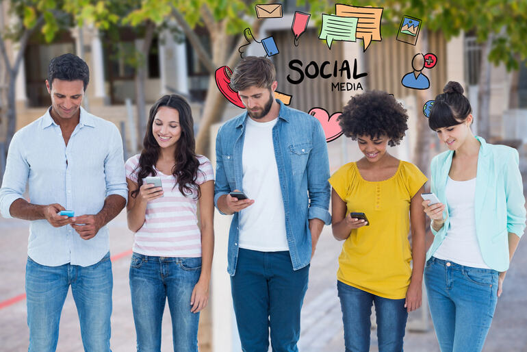 A diverse group of young adults walking outdoors while using smartphones
