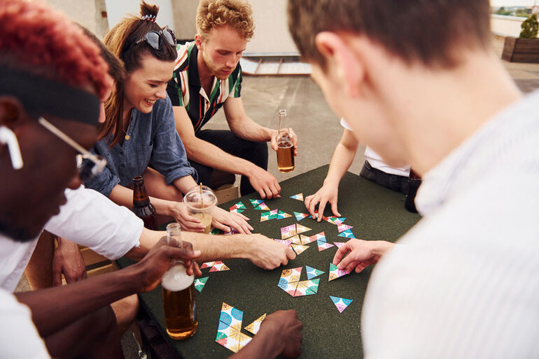 Friends playing at a table with craft beer.
