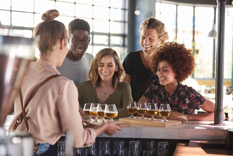 A group of friends is enjoying beer-tasting at a home setting