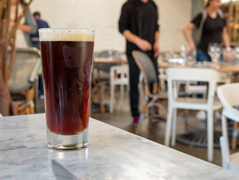 A glass of craft beer on a diner’s table.