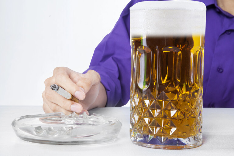 A glass of Filipino beer in front of a man.