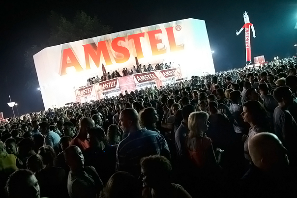 Large crowd of people in front of Amstel banner