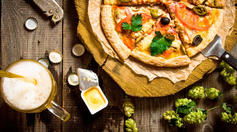 Beer with pizza on a rustic table for international food pairing
