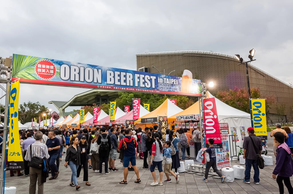 People walking under a banner reading "Orion Beer Fest"
