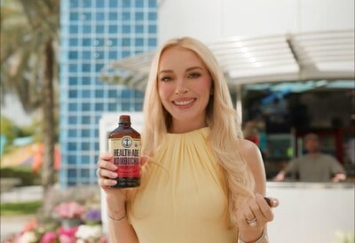 Lindsay Lohan holding Health-Ade Kombucha Bottle
