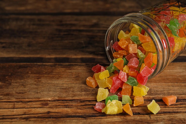 Jar of Delta 9 gummies placed on a wooden table, highlighting key considerations for beer lovers before purchasing.