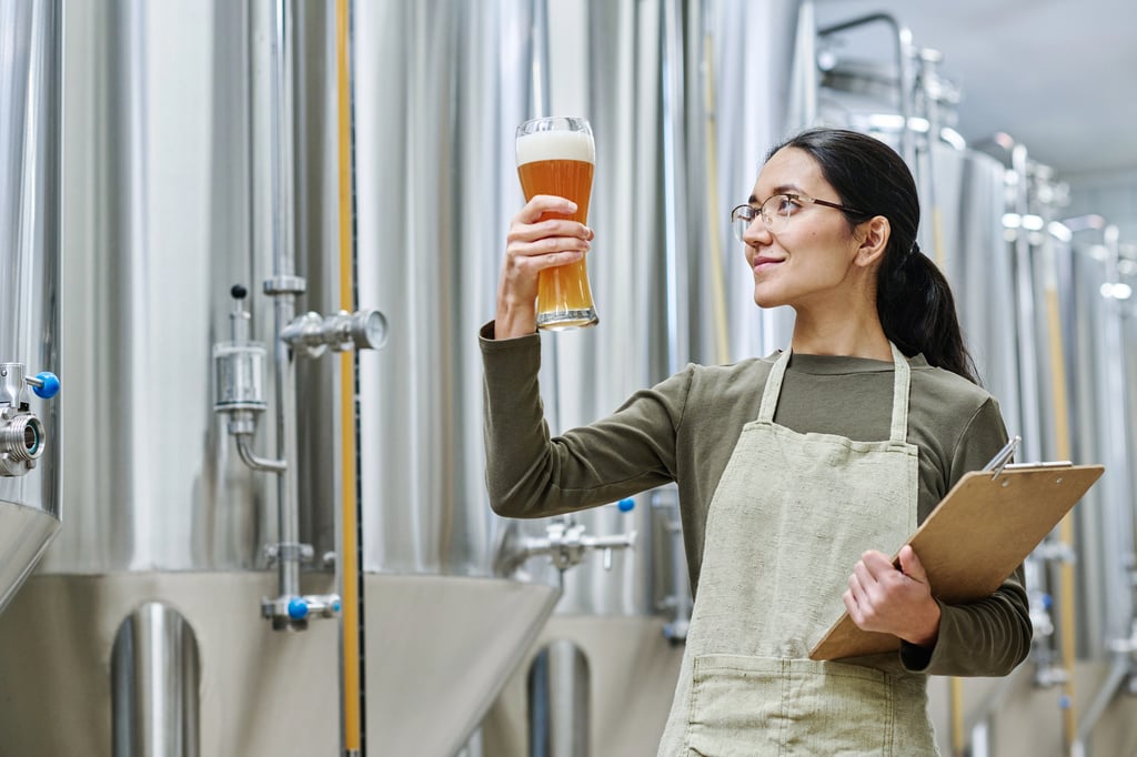 Brewer employing sensory analysis in the brewhouse with a clipboard.