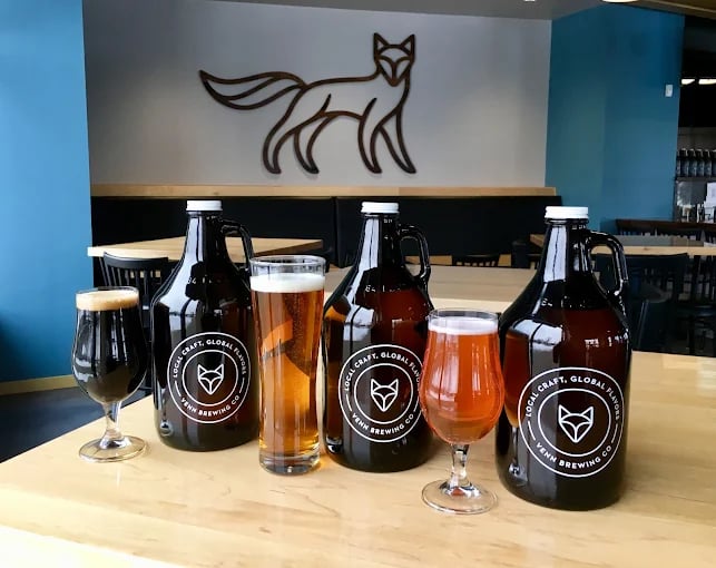 Venn Brewing taproom with selected beers in glasses and growlers atop a table.